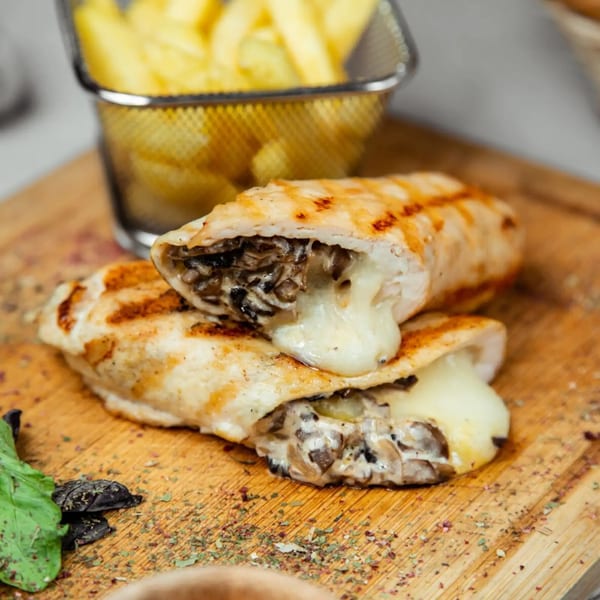 Grilled chicken stuffed with mushrooms and melted cheese, served with french fries.